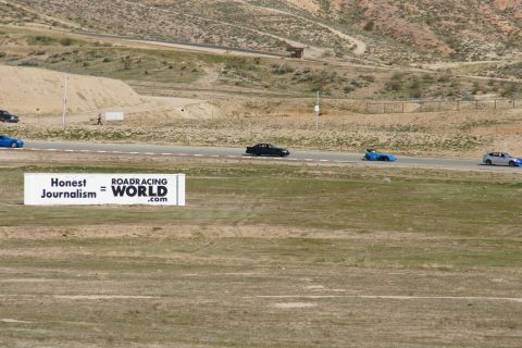 1995 Ford Taurus - Several cars are seen racing on a track, with a large sign in the foreground reading "Honest Journalism = ROADRACING WORLD.com".