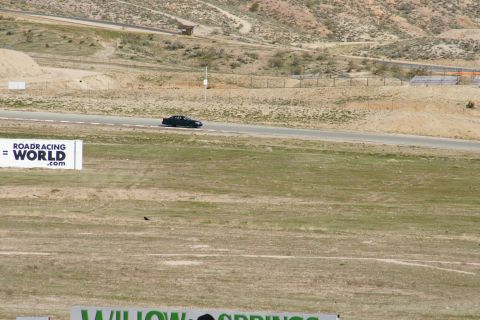 1995 Ford Taurus - A black sedan drives on a race track with a sign for Roadracingworld.com in the foreground.