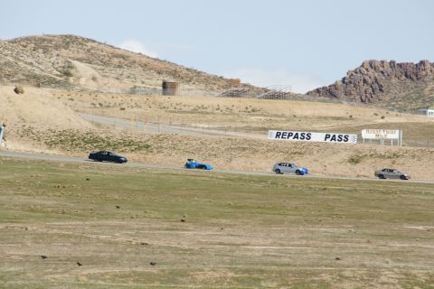 1995 Ford Taurus - A group of cars navigates a turn on a race track, with a sign indicating 'REPASS PASS'.