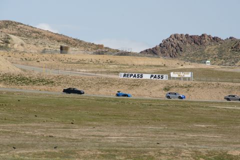 1995 Ford Taurus - Multiple vehicles race on a track under a bright sky, with signs indicating track rules.