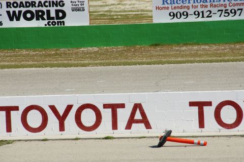 1995 Ford Taurus - A race track scene with a TOYOTA logo painted on a wall and a traffic cone lying on the asphalt.