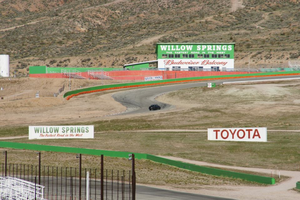 Black sedan on a race track with Willow Springs and Toyota signs