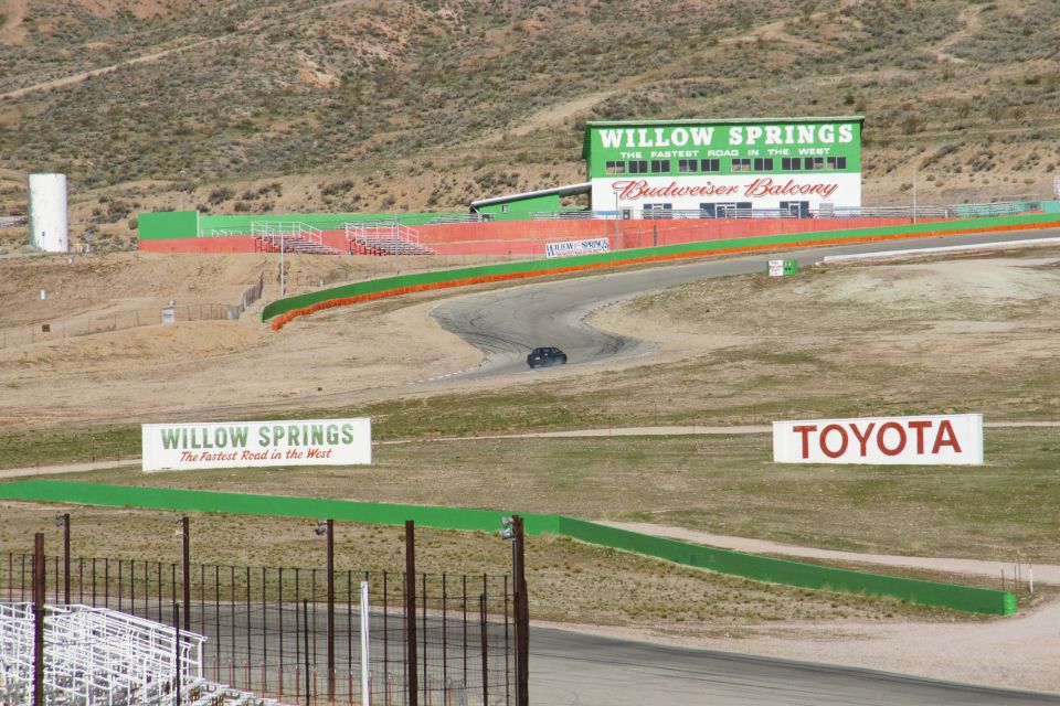 car on a race track with Willow Springs and Toyota signs visible