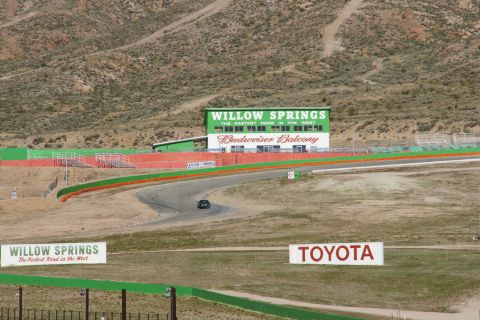 1995 Ford Taurus - A lone car navigates the Willow Springs International Raceway, with the Budweiser Balcony visible.