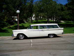1963 Ford Galaxie - A white station wagon is parked on asphalt with a grassy area and trees behind it.