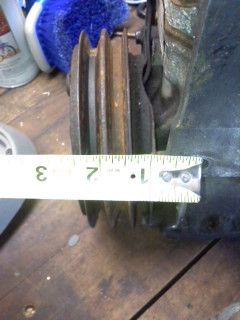 1977 Ford F-100 - Measuring a ribbed pulley with a tape measure on a workbench.