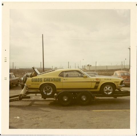 1973 Ford Mustang - A yellow race car, possibly a Boss 302 Mustang, is loaded onto a trailer.