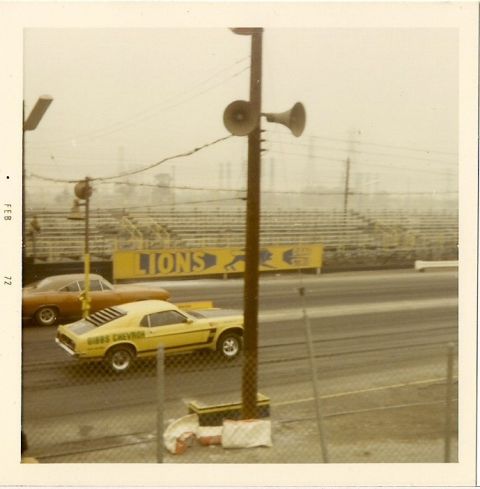 1973 Ford Mustang - Yellow 1970 Ford Mustang Mach 1 and an orange car at a drag strip with Lions banner.