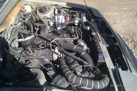 2000 Mercury Grand Marquis - The engine bay of a vehicle, showing various hoses, wiring, and engine components.