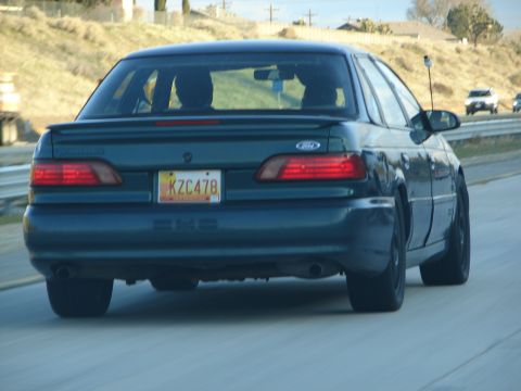 1992 Ford Taurus - This dark green 1992 Ford Taurus is seen from the rear on a highway.