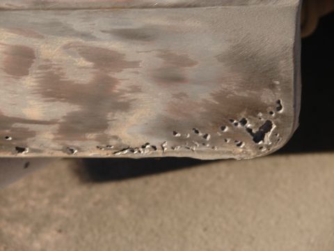1973 Ford Ranchero - Close-up of a corroded metal panel, showing significant rust damage and pitting.