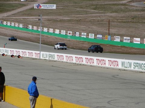 1992 Ford Taurus - Two cars are seen on the Willow Springs race track, with a blue go-kart in the distance.