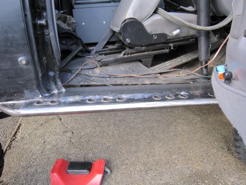 1996 Ford Bronco - Custom rock sliders are installed on the side of a vehicle, with a view of the interior.