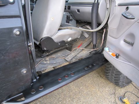 1996 Ford Bronco - Interior view of a vehicle with the driver's door open, revealing the seat and custom side steps.