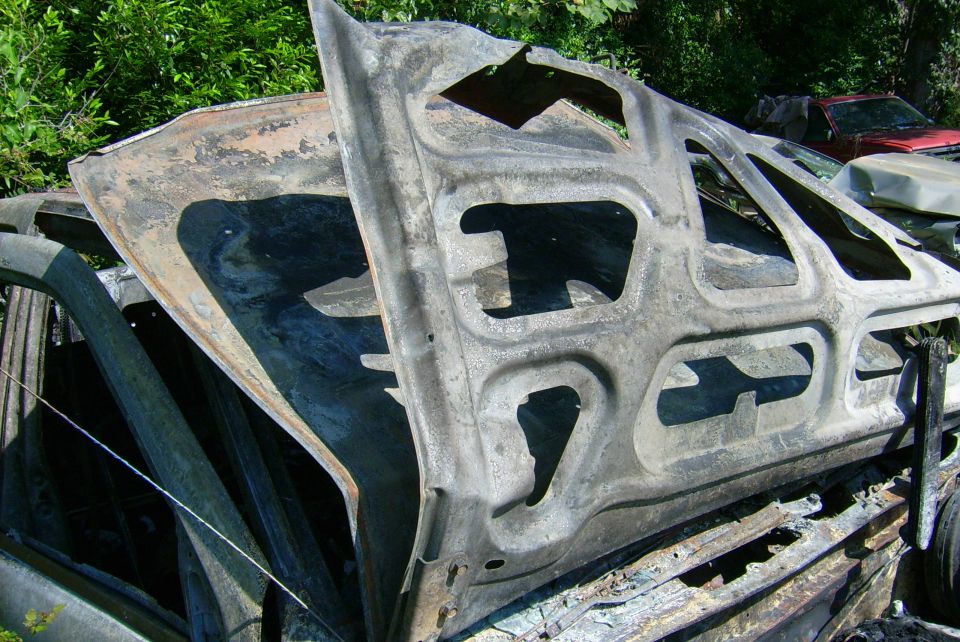Burnt car door and frame, showing structural reinforcement and damage