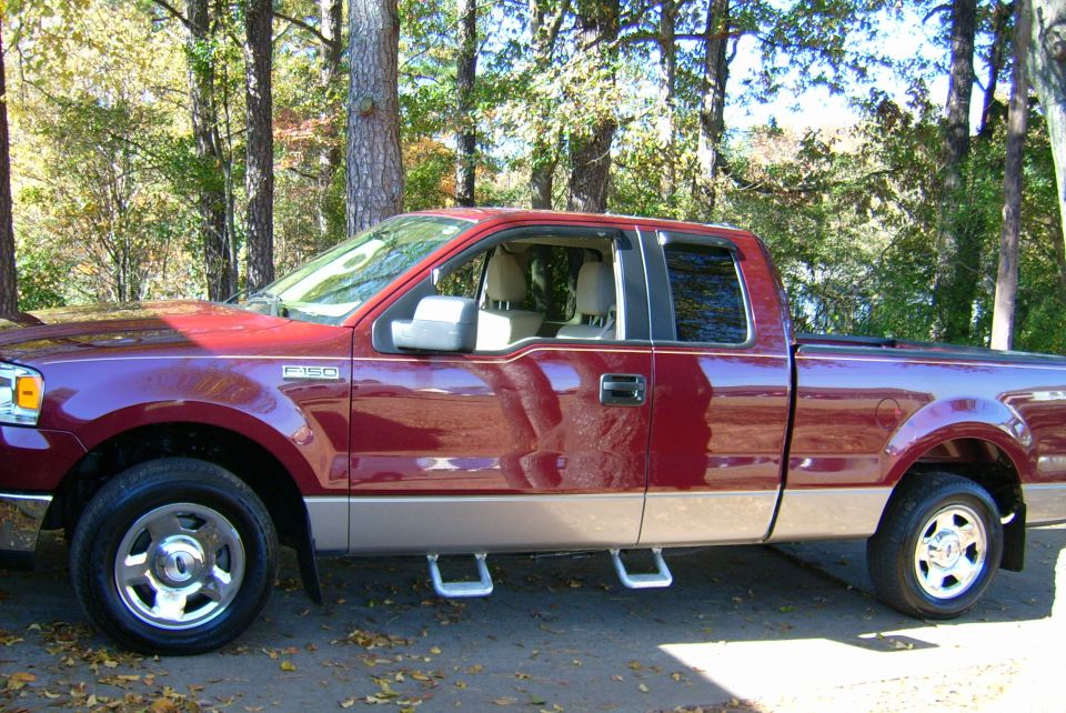 Maroon Ford F-150 pickup truck with tan lower body panels and running boards parked outdoors