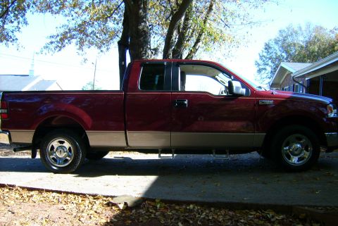 1981 Toyota Hilux - A red pickup truck with tan lower body is parked on an asphalt surface.
