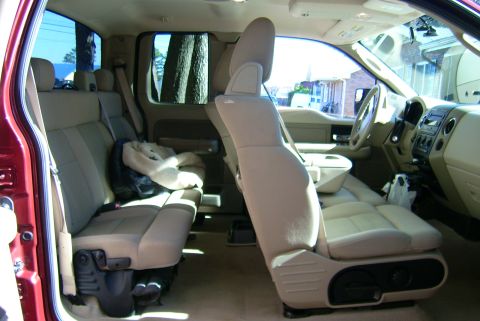 1981 Toyota Hilux - The interior of a pickup truck shows the front and rear seating areas, with a focus on the beige upholstery and dashboard.