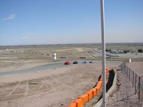 1992 Ford Taurus - Multiple cars race on a track under a clear blue sky.