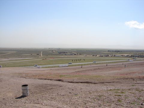 1992 Ford Taurus - A wide view of a race track with distant structures and a hazy mountain range on the horizon.