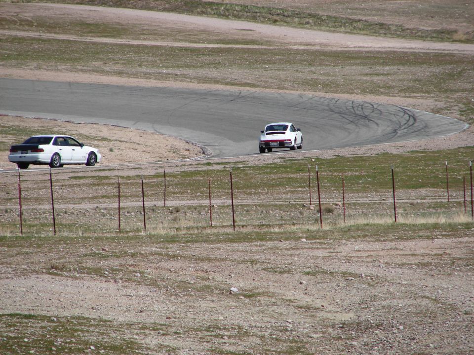 White sedan and white coupe on race track