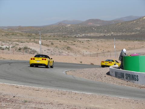 1992 Ford Taurus - Two yellow Chevrolet Corvettes are seen on the Willow Springs race track. The lead car is viewed from the rear, showing its 2005 model year…