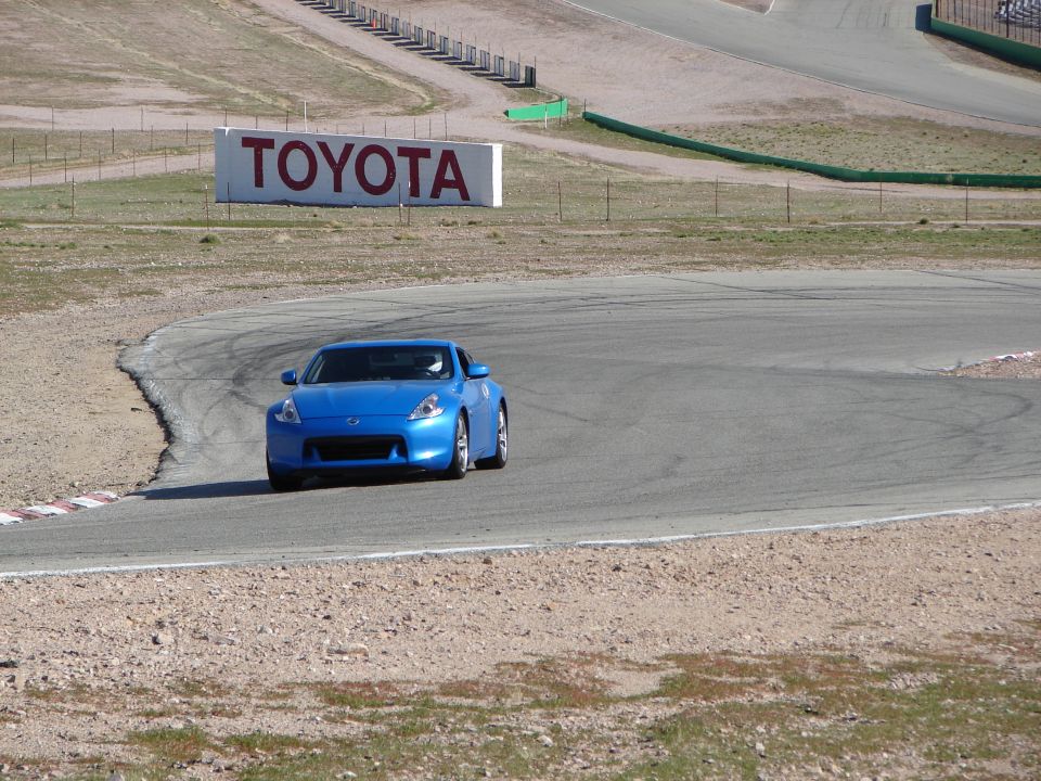 Blue sports car on a race track with a TOYOTA sign in the background