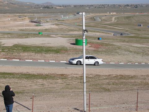 1992 Ford Taurus - A white 1992 Ford Taurus sedan with a black hood is seen on a race track during a sunny day.