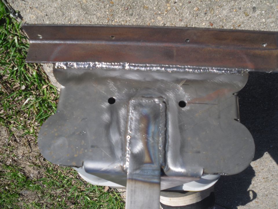 Welded metal bracket with two holes and a L-shaped metal piece attached