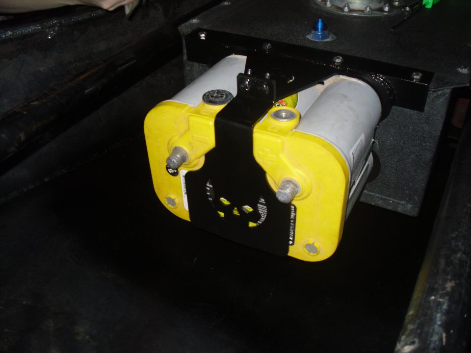 Close-up of a yellow and silver fuel pump assembly mounted in a dark interior