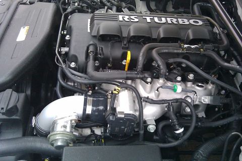 2010 Hyundai Genesis - Close-up view of an engine's intake system, showing "RS TURBO" lettering on the engine cover.