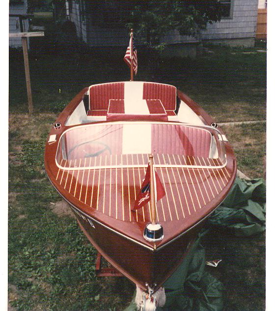 Wooden boat front view with red and white interior and American flag