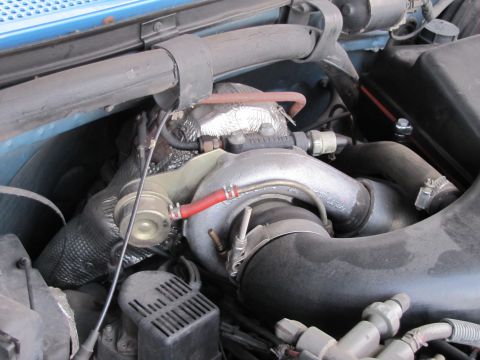 1993 Ford F-250 - Close-up view of a turbocharger system, likely from a truck, showing various hoses and metal components.