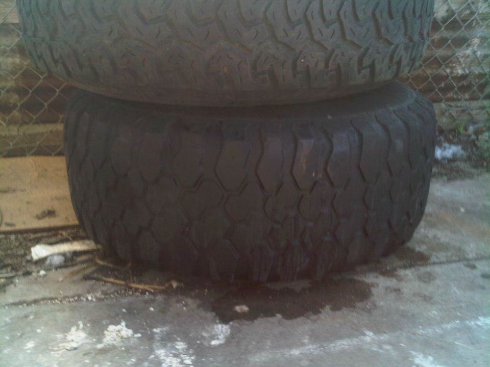 two off-road tires stacked on concrete