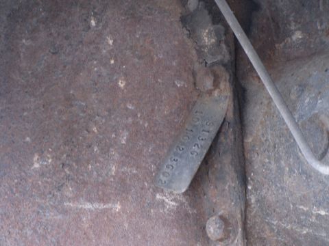 1993 Ford F-250 - A close-up view of a stamped metal tag with serial numbers, attached to a rusty surface.