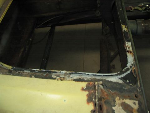 1970 Ford Mustang - Close-up view of a heavily rusted car frame, revealing internal structural components.