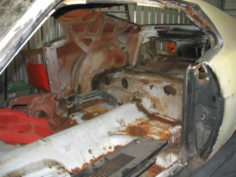 1970 Ford Mustang - The interior of a 1970 Ford Mustang shows significant rust damage, indicating a need for extensive restoration.