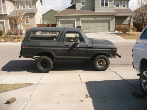 1979 Ford Bronco - A side view of a lifted Ford Bronco, possibly a 1978 model, parked in a driveway.