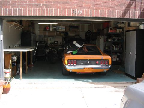 1970 Ford Mustang - Rear view of an orange 1970 Ford Mustang, identified by its distinctive taillights and BOSS 302 badging.