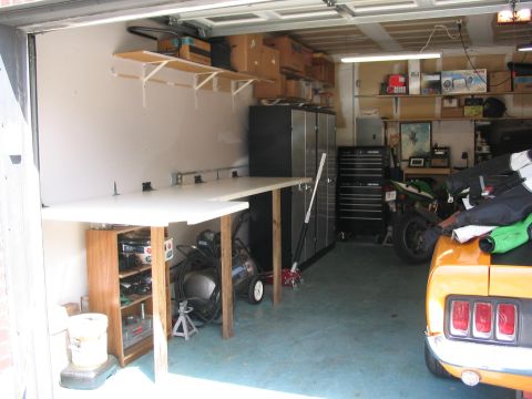 1970 Ford Mustang - A 1970 Ford Mustang is parked in a garage next to a motorcycle and workbench.