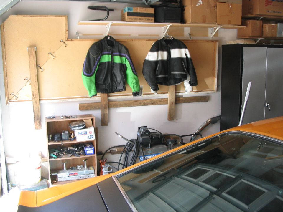 Orange car interior with motorcycle jackets and parts in garage