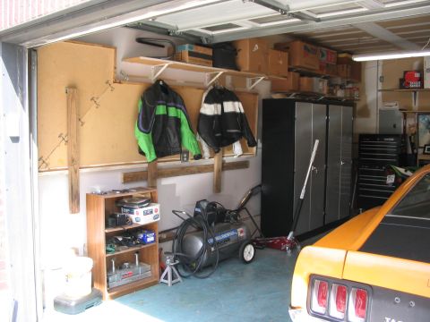 1970 Ford Mustang - A garage scene with an orange car, air compressor, and storage units.