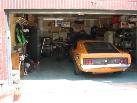 1970 Ford Mustang - Rear view of an orange 1970 Ford Mustang in a cluttered garage.