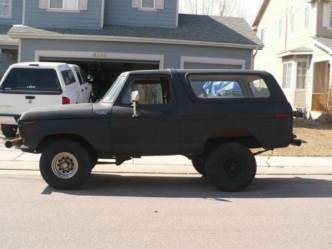 1979 Ford Bronco - Side view of a black 1979 Ford Bronco parked on a residential street.