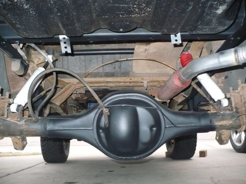 1979 Ford Bronco - The underside of a vehicle shows the rear axle assembly, including the differential, shocks, and exhaust system.