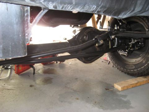 2008 Ford F-250 - The rear axle and suspension system of a vehicle are visible from below, with a tire on the right side.
