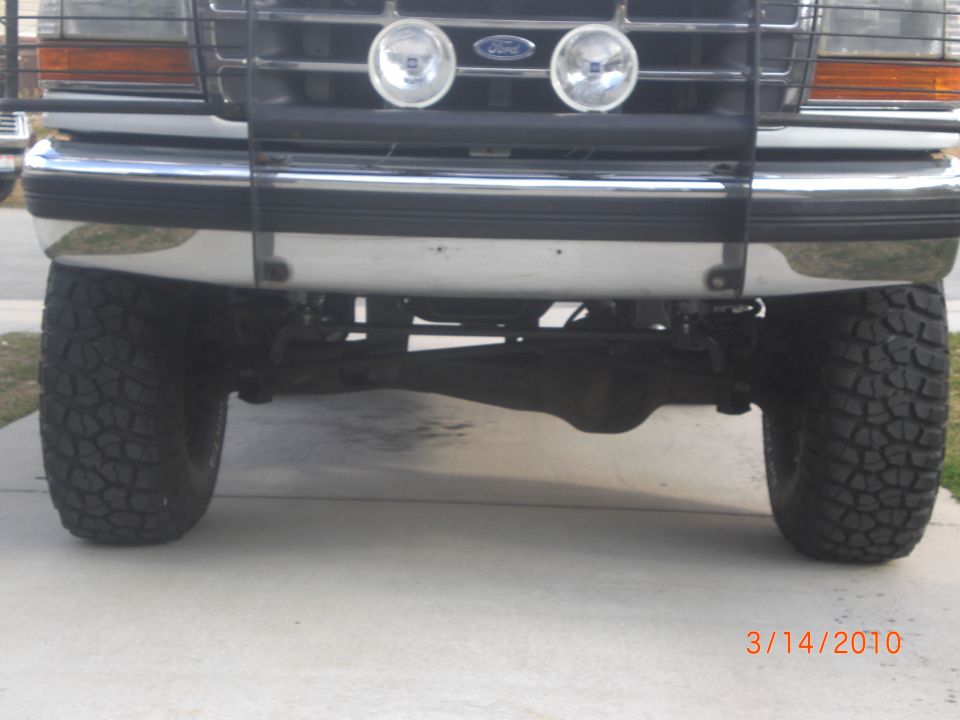 Front view of a lifted 1992 Ford Bronco with large tires and a chrome bumper