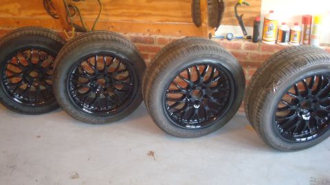 2004 Ford Crown Victoria - Four black aftermarket rims and tires are displayed in a garage setting. The registry claims they are for a 2004 Ford Crown Victoria.