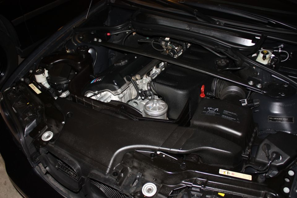 BMW engine bay with M-badged cam cover, strut brace and black airbox