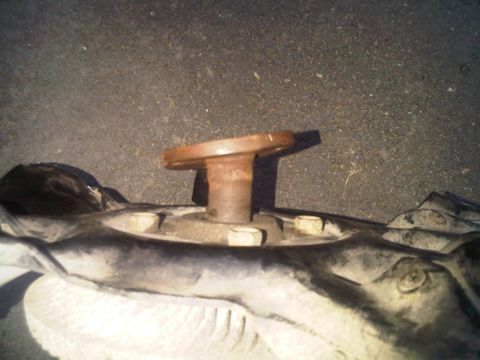 1996 Ford Bronco - A close-up view of a rusted metal component with bolts, likely part of a vehicle's undercarriage.
